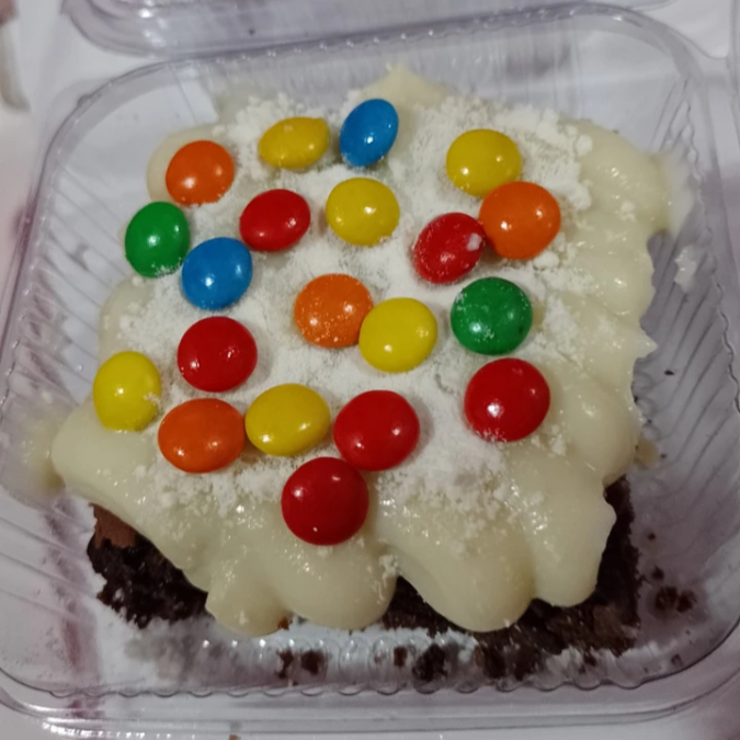Brownie com cobertura de brigadeiro de leite ninho e m&m por cima