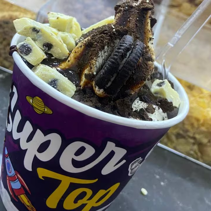 Baunilha, calda da sua preferência, biscoito Oreo e pedaços de chocolate branco c/ Oreo. Copo de 300ml