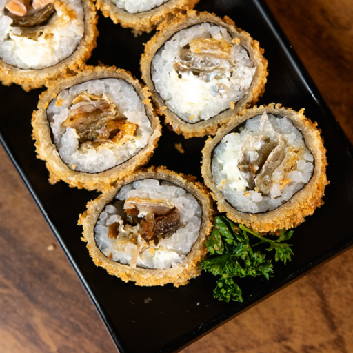 Rolo de sushi com recheio de Skin ( PELE DE SALMÃO FRITA ), cream Cheese e arroz, empanado e frito por fora.