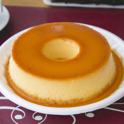 Clássico pudim cremoso, com textura aveludada e cobertura de caramelo dourado, derretendo na boca a cada colherada.