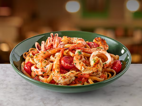 Linguine preparado ao molho de tomate cubetti temperado. Servido com camarões grelhados e lula.