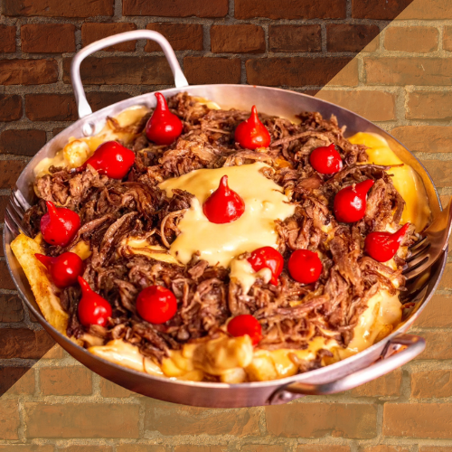 Batata crinckle coberta com costela desfiada e catupiry, finalizada com pimenta biquinho e cebolinha.