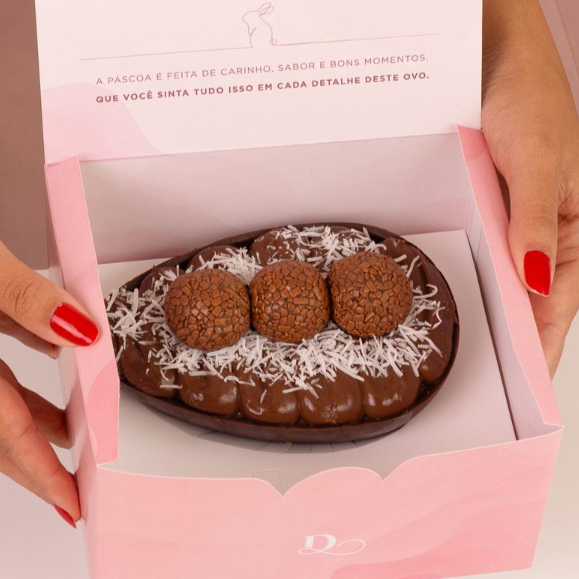 Ovo de Páscoa feito com casca de chocolate nobre ao leite, recheada com coco cremoso e brigadeiro tradicional. Finalizado com 3 brigadeiros e acompanha sacola presente Dandoce. 500G