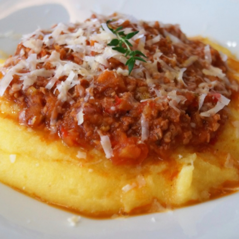 Polenta cremosa e aveludada, preparada lentamente, coberta com suculento ragú de fraldinha cozido por horas em molho encorpado de tomate e ervas, finalizada com parmesão ralado na hora. Um prato rústico, reconfortante e cheio de sabor, perfeito para quem aprecia a verdadeira cozinha artesanal.