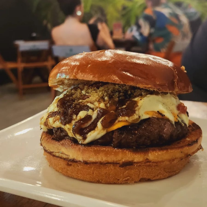 Pão, Hambúrguer angus, Queijo cheddar, farofa de bacon, Cebola caramelizada e molho da casa