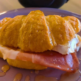 Croissant grande Recheado com queijo brie e fatias de presunto parma. Finalizado com Mel