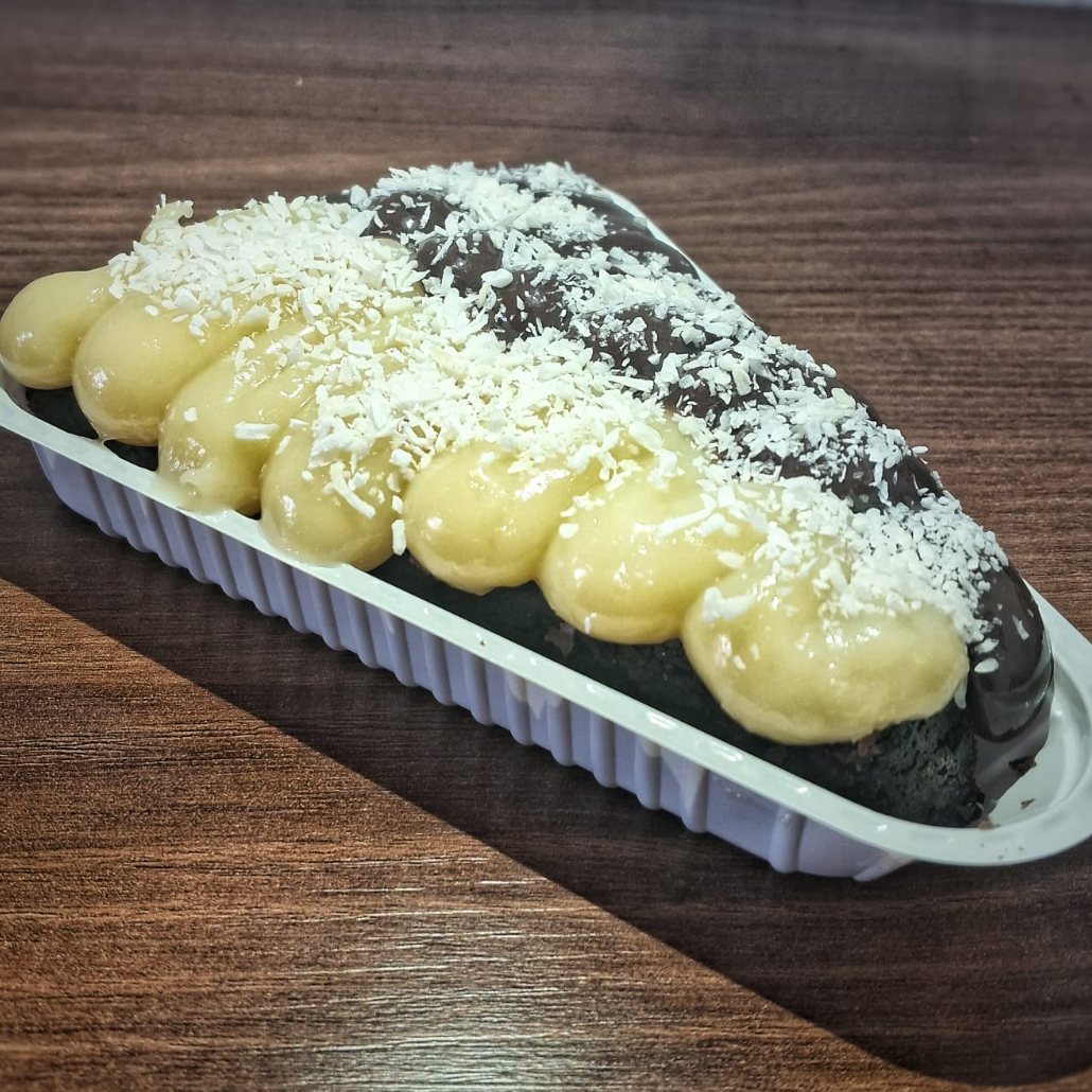 Brownie de chocolate meio amargo com duas camadas: metade com brigadeiro e metade com coco cremoso. Finalizado com coco ralado para reforçar o sabor. Uma versão inspirada no clássico prestígio, com equilíbrio entre chocolate e coco.