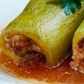 Abobrinha recheada com arroz e carne moída, cozida no molho vermelho. Porção com 2 abobrinhas recheadas.