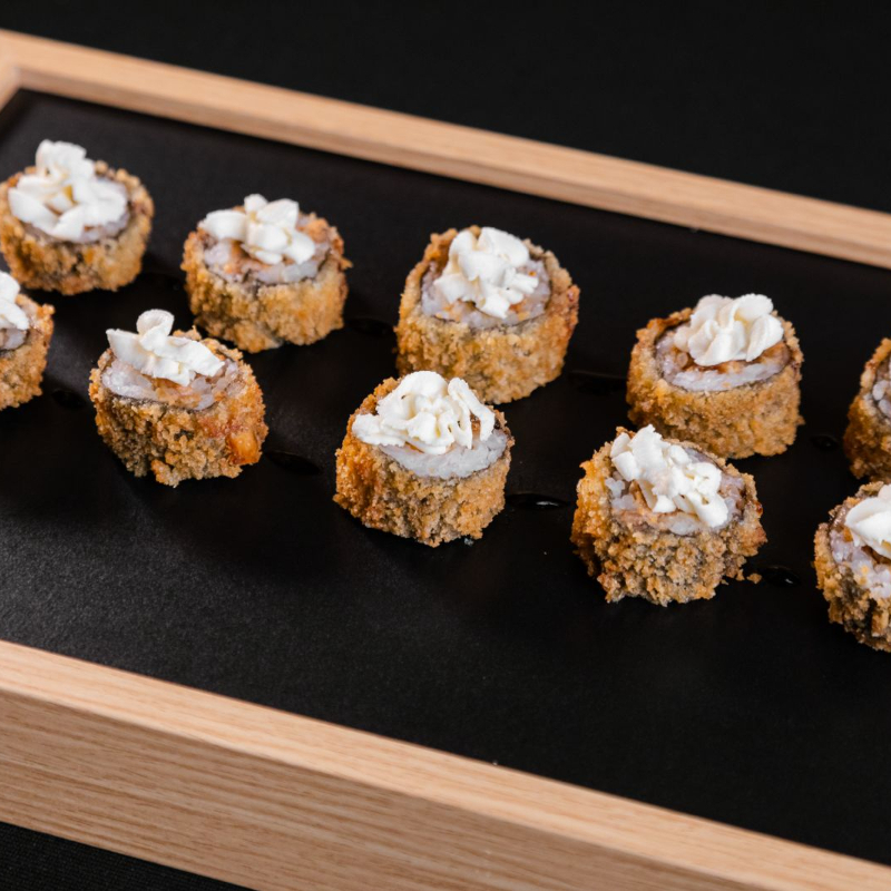 Rolinho empanado e frito, recheado com salmão e cream cheese. Finalizado com cream cheese e molho tarê. Crocância e sabor em cada pedaço! Não acompanha shoyu, tarê e wasabi.