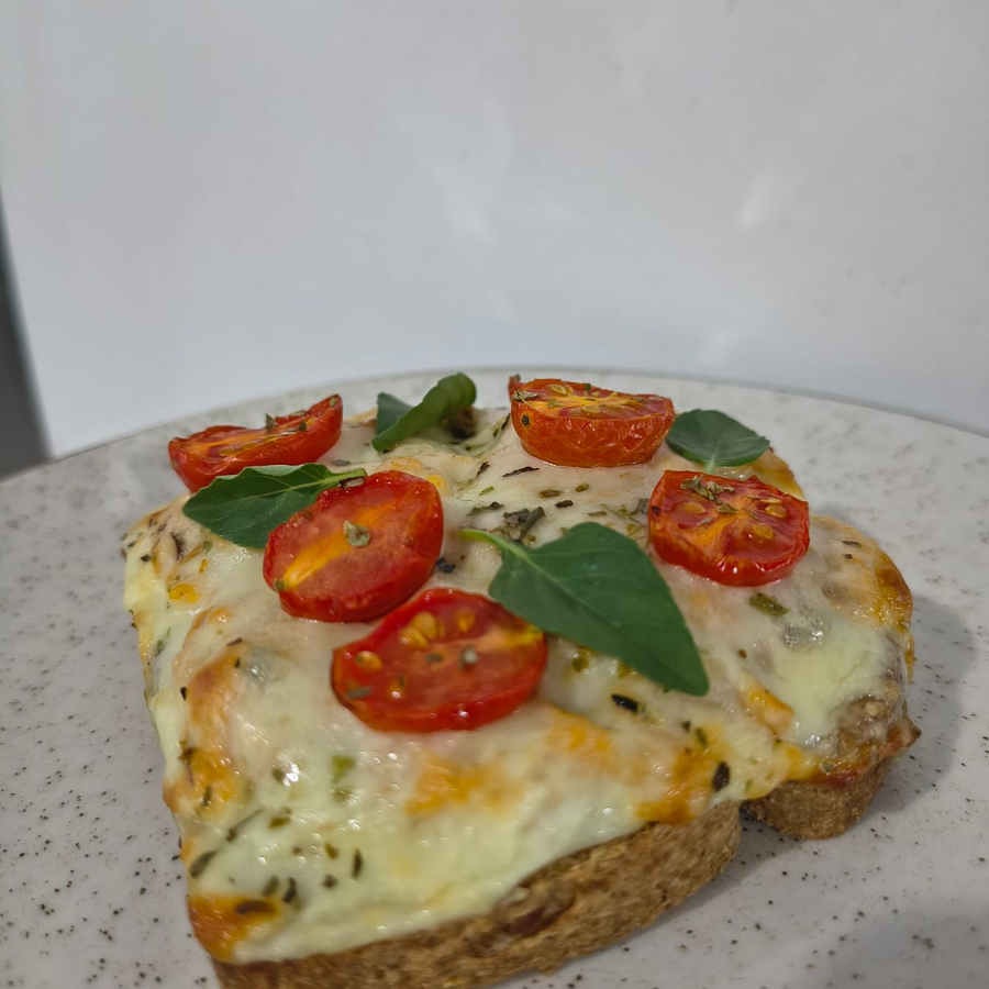 Toast Delicatto: Fatia de pão multigrãos levemente crocante, recheio de frango, queijo mussarela gratinado, tomate cereja, finalizado com orégano.
