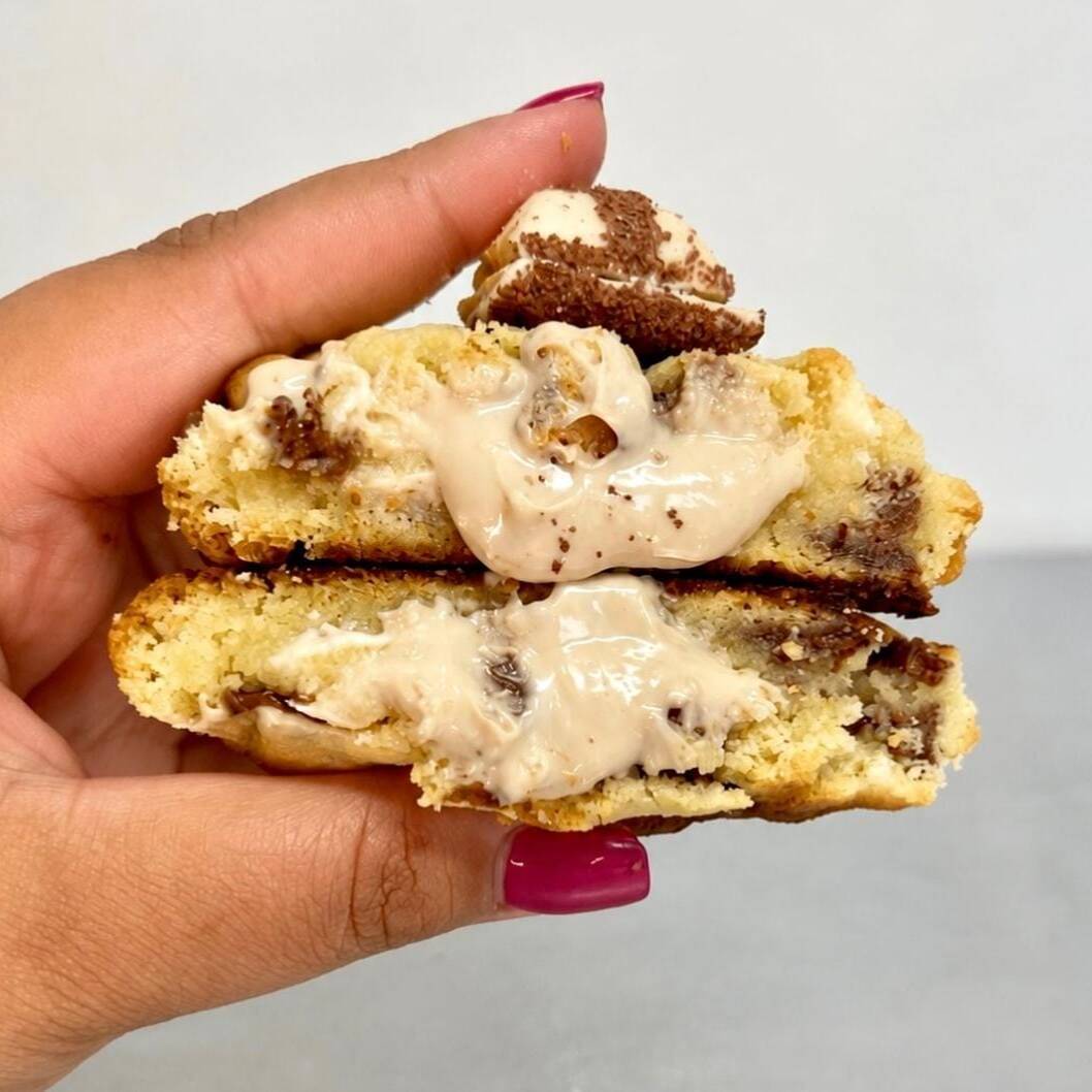 Cookie de massa tradicional, recheado com um creme de bueno, o mesmo do kinder bueno, e finalizado com gotas mistas de chocolate branco e ao leite e um kinderzinho no topo.