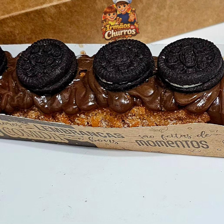 Delicioso churros gourmet salpicado com açúcar de confeiteiro e canela em pó com recheio e cobertura de doce de leite ou doce de chocolate coberto com mini Oreo por cima.