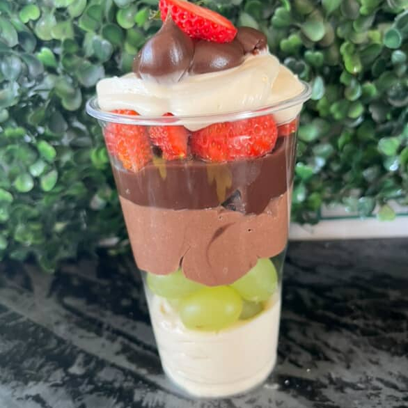 Feito com mousse de ninho, brigadeiro e mousse chocolate , finalizado com uvas verdes e morangos frescos