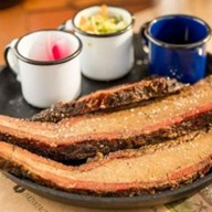 Costelinha suína defumada por aproximadamente 1h no estilo texano, com nosso Dry Rub Especial. Finalizada com molho BBQ de Jack Daniel's, acompanhada de salada coleslaw e picles de pepino