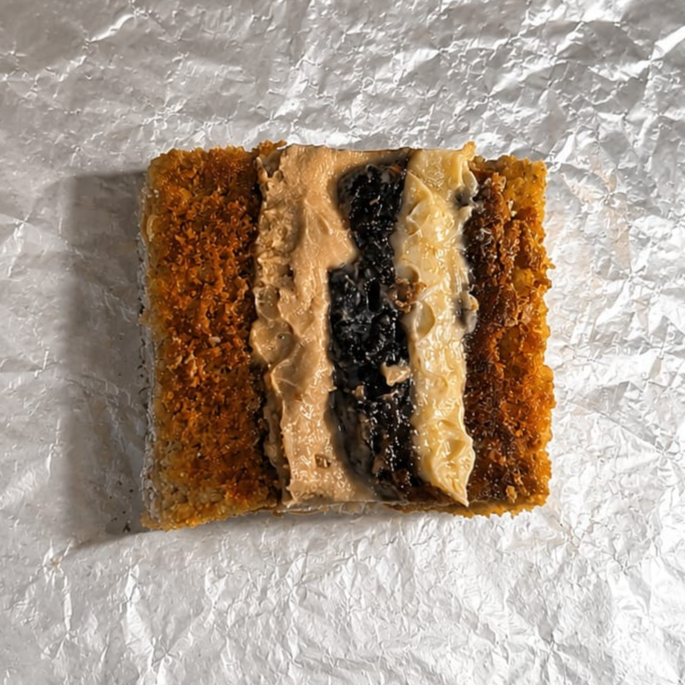 massa branca deliciosa com doce de leite cremoso, cocada e aquela maravilha de ameixa preta aproximadamente 150g