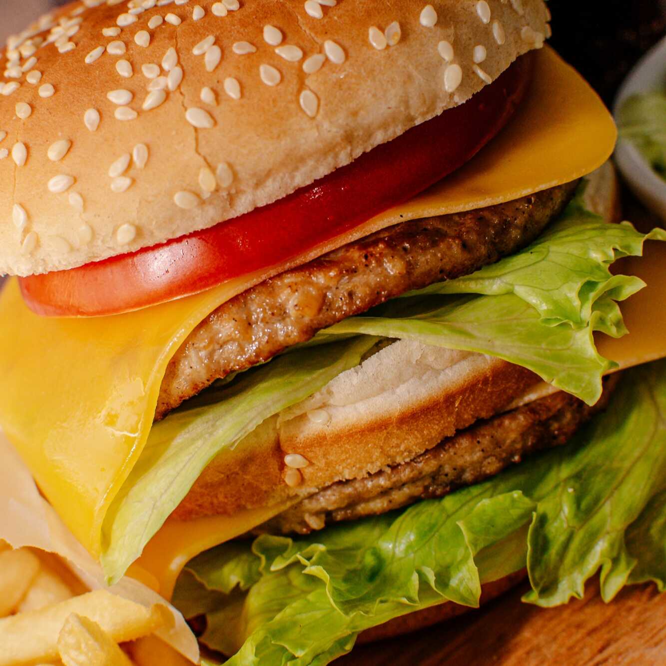 Pão duplo com gergelim, duas carnes bovina de 56g, queijo prato, alface americana e tomate