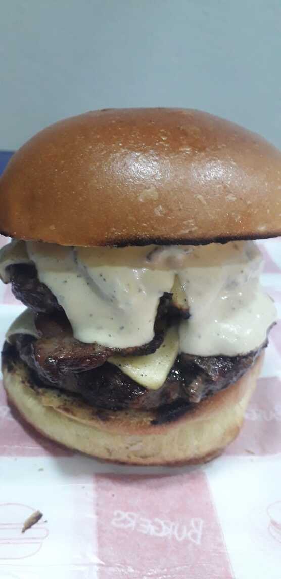 Pão de brioche , 2 blend bovino 120g , 2 fatias de queijo mussarela , 2 fatias de bacons , geleia de cebola caramelizada , maionese de ervas .