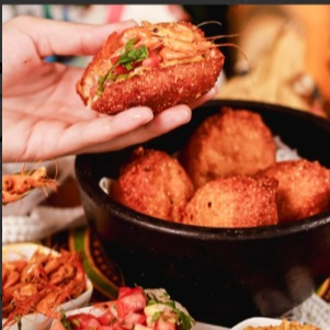 Delicie-se com uma porção de cinco mini-acarajés, servidos com um autêntico vatapá de sabor inconfundível, molho lambão e camarão seco (com cabeça como manda a receita Original) que traz a essência da culinária nordestina. Para acompanhar, uma lata de Coca-Cola geladinha, oferecendo a combinação perfeita de sabores.