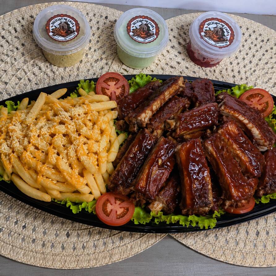 Petiscos de costelinhas de porco ao molho barbecue com batata frita, acompanhado de molho especial, pimenta e farofa.