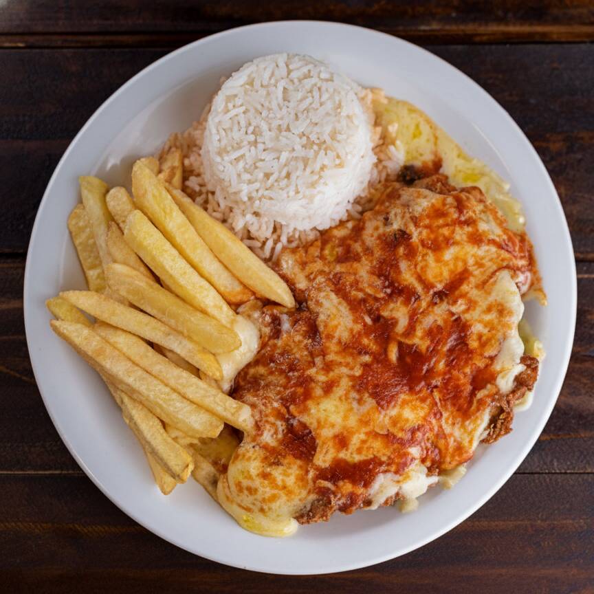 Filé de frango empanado, coberto com molho de tomate caseiro e queijo derretido. Acompanha arroz branco e fritas crocantes. Um clássico que todo mundo ama!