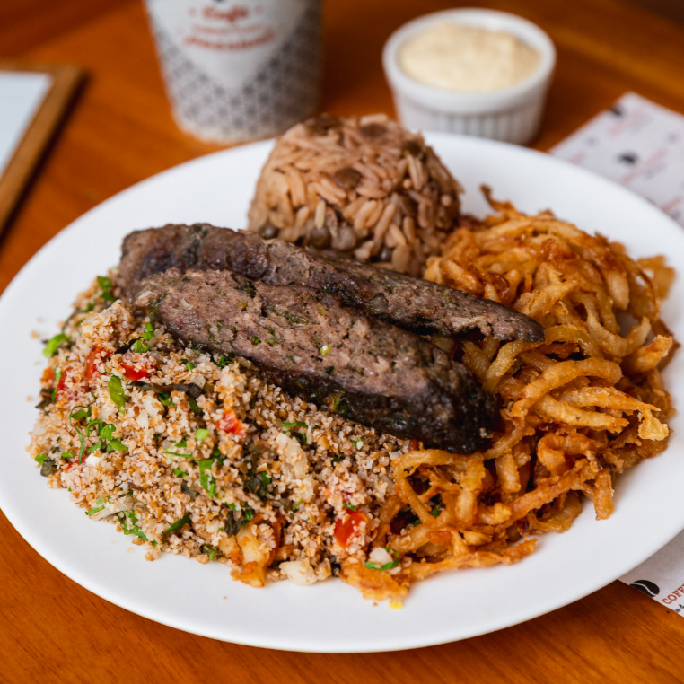 Arroz com lentilha, cebola crispy, kafta carne e salada tabule. (Acompnha pastinha homus.)
