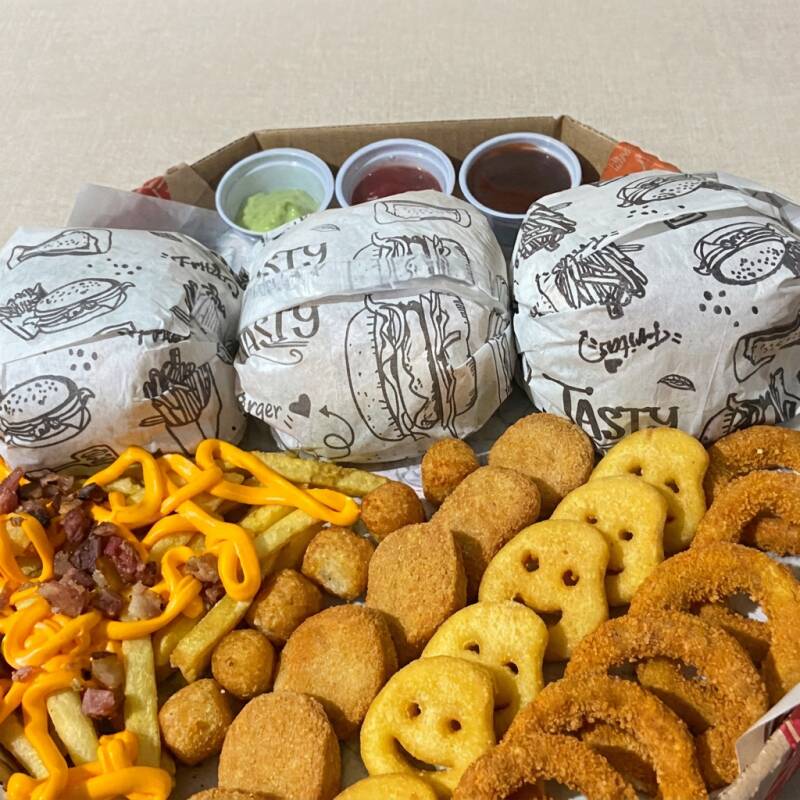 3 Hamburguer , 150g de fritas cm cheddar e bacon , 6 anel de cebola , 6 nugget , 6 batata carinhas , 6 mandioquinha . OBSERVAÇÃO ; AS BATATAS PODEM CHEGAREM MURCHAS DEVIDO A EMBALAGEM FECHADA .