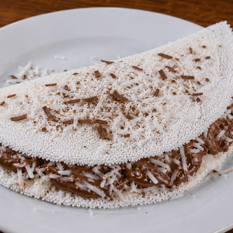 Uma sobremesa em forma de tapioca! Preparada na hora, ela combina o sabor irresistível do chocolate Suflair, coco ralado e leite condensado, criando uma explosão de cremosidade e doçura em cada mordida. Perfeita para quem ama chocolate e não resiste a um toque especial de coco.
