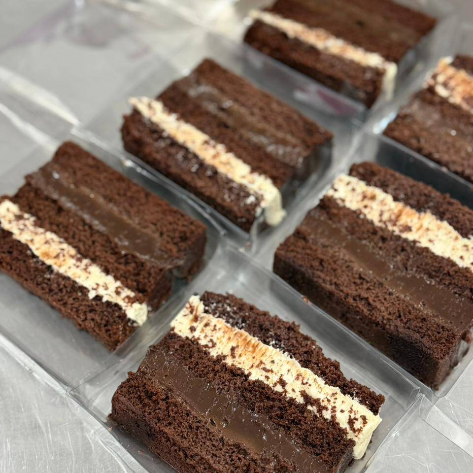 Fatia de bolo de chocolate recheado com brigadeiro, ninho e brigadeiro e outros recheios
