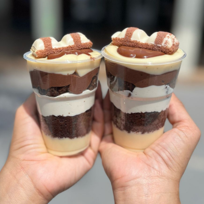 Um delicioso copo da feicidade com brownie, bolo de chocolate, brigadeiro branco, mousse de ninho e chocolate 50% cacau finalizado com Nutella e Kinder bueno servindo muito bem 1 pessoa, 200ml.