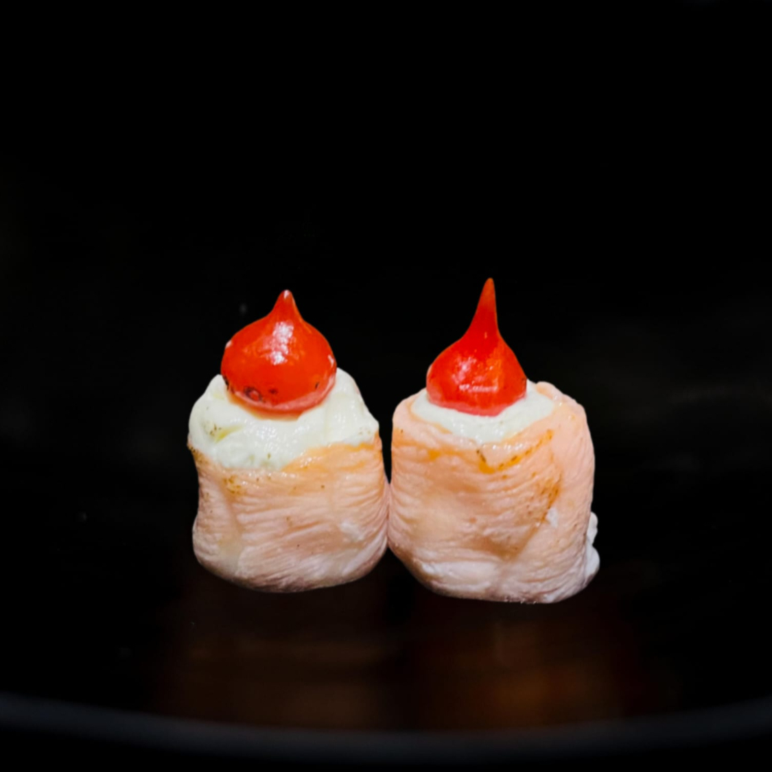 Salmão selado recheado com arroz. Cream cheese e pimenta biquinho por cima. A porção deste item acompanha 1 molho teriyaki / tarê (30ml)