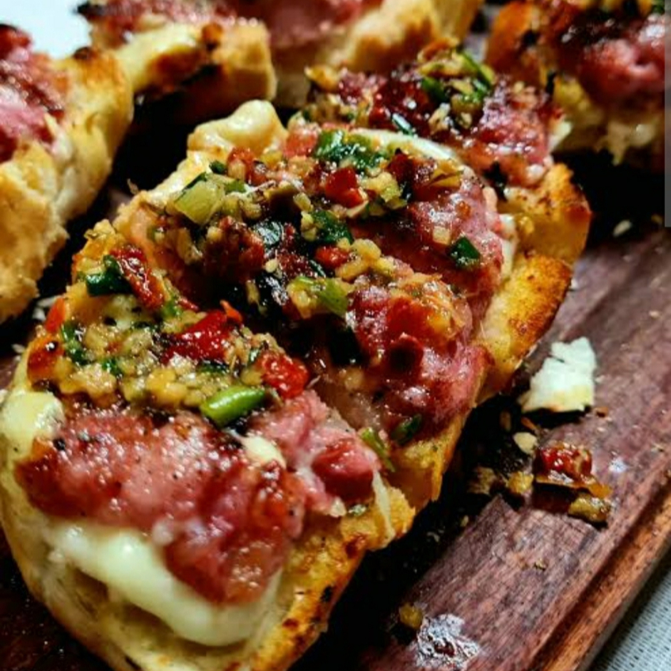 Linguiça Suína Toscana Assada na tortilha de trigo frita no azeite de dedo de moça, flakes de repolho fininhos, batata palha, cream chesse, molho chimichurri da casa levemente picante.