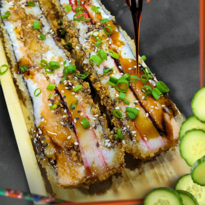 A Explosão de Crocância! Experimente a combinação perfeita entre o tradicional e o inovador. Nosso Sushi Prime é montado em camadas generosas de arroz japonês temperado, salmão fresco, kani, camarão e cream cheese, tudo envolto em uma casquinha ultra crocante de farinha Panko. Finalizado com Cebolinha fresca, gergelim selecionado e um fio generoso de molho tarê especial.