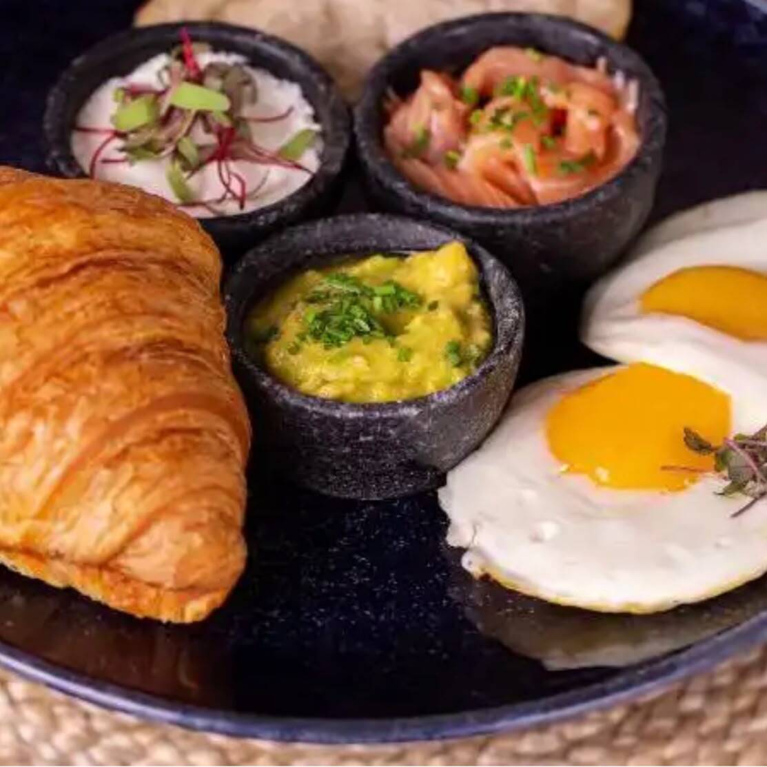 1 croissant, 1 fatia de sourdough, salmão curado, 2 ovos fritos, guacamole e queijo de cabra.