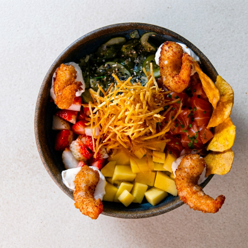 O 'Poke Lovato', categorizado como um dos nossos melhores 'Pokes', é uma verdadeira explosão de sabores. Tem como base o arroz, complementado por um sunomono crocante e ácido, que equilibra a untuosidade do salmão fresco e suculento. Além disso, a manga doce e madura, juntamente com o morango, adicionam um toque frutado e vibrante ao prato. O queijo cremoso, conhecido como 'Cream Cheese', aveluda a experiência, enquanto o camarão, bem temperado e suavemente cozido, finaliza com um toque marítimo. Uma verdadeira sinfonia de texturas e sabores que irá encantar o seu paladar.