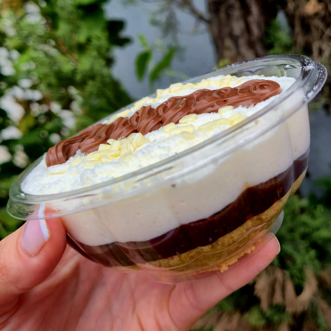 ossa versão da clássica combinação preto e branco. Base de biscoito crocante, recheio denso de brigadeiro ao leite artesanal e cobertura leve de mousse de Leite Ninho. Finalizada com Nutella legítima, garantindo um equilíbrio sofisticado entre a intensidade do cacau e a suavidade do leite.