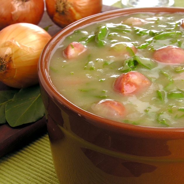 Nosso Caldo Verde combina a cremosidade do tradicional purê de batata e a leveza da couve finamente cortada com um toque de defumado. A base, preparada com o nosso tempero caseiro exclusivo, recebe bacon crocante e calabresa triturada, adicionando uma camada extra de sabor irresistível. Para finalizar, um toque sutil de coentro fresco eleva o sabor, servido com um pãozinho para acompanhar. Uma experiência única e cheia de personalidade.