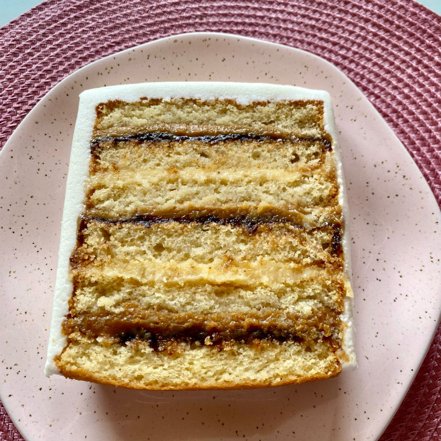 Descrição: Bolo de massa branca especial, molhadinha com calda de leite de coco. 5 camadas de recheios intercaladas.  Doce de leite com geleia de ameixa, beijinho de coco e finalizado com glacê mármore. Aproximadamente 300 gr