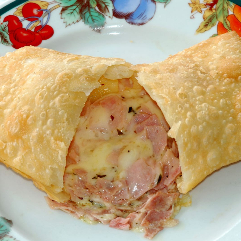 Pastel de Pizza 20 cm Pastel grande e crocante de 20 cm, recheado com mussarela derretida, presunto , orégano e tomate. Combinação clássica com sabor de pizza e massa douradinha que deixa cada mordida irresistível!