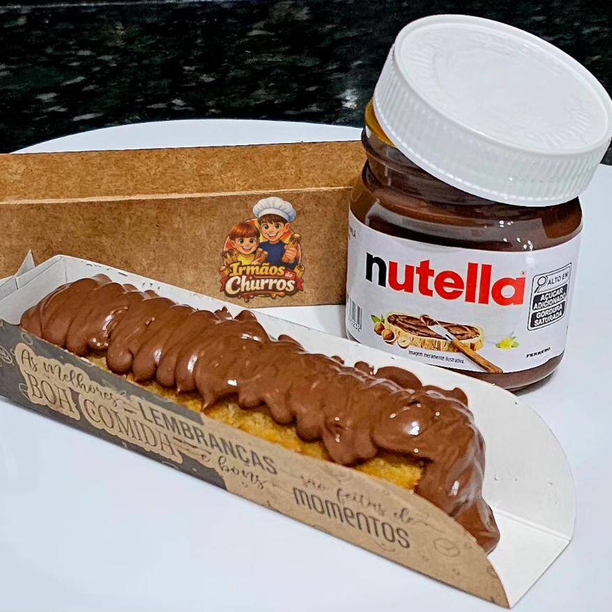Delicioso Churros salpicado com açúcar de confeiteiro e canela em pó com recheio e cobertura de Nutella.