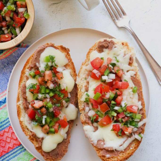 Molletes de frijoles con queso gratinado y salsa