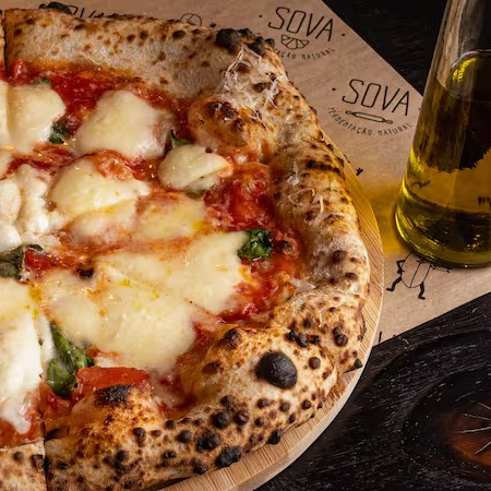 Massa de fermentação natural, molho de tomate italiano, mussarela de búfala, pecorino e manjericão Obs: por padrão, a pizza é enviada inteira (não fatiada) para garantir uma melhor conservação e mantê-la quente por mais tempo (além de facilitar caso você queira reaquecê-la no forno ao recebê-la). Se preferir que enviemos a pizza cortada em fatias, favor especificar na observação do pedido ;)