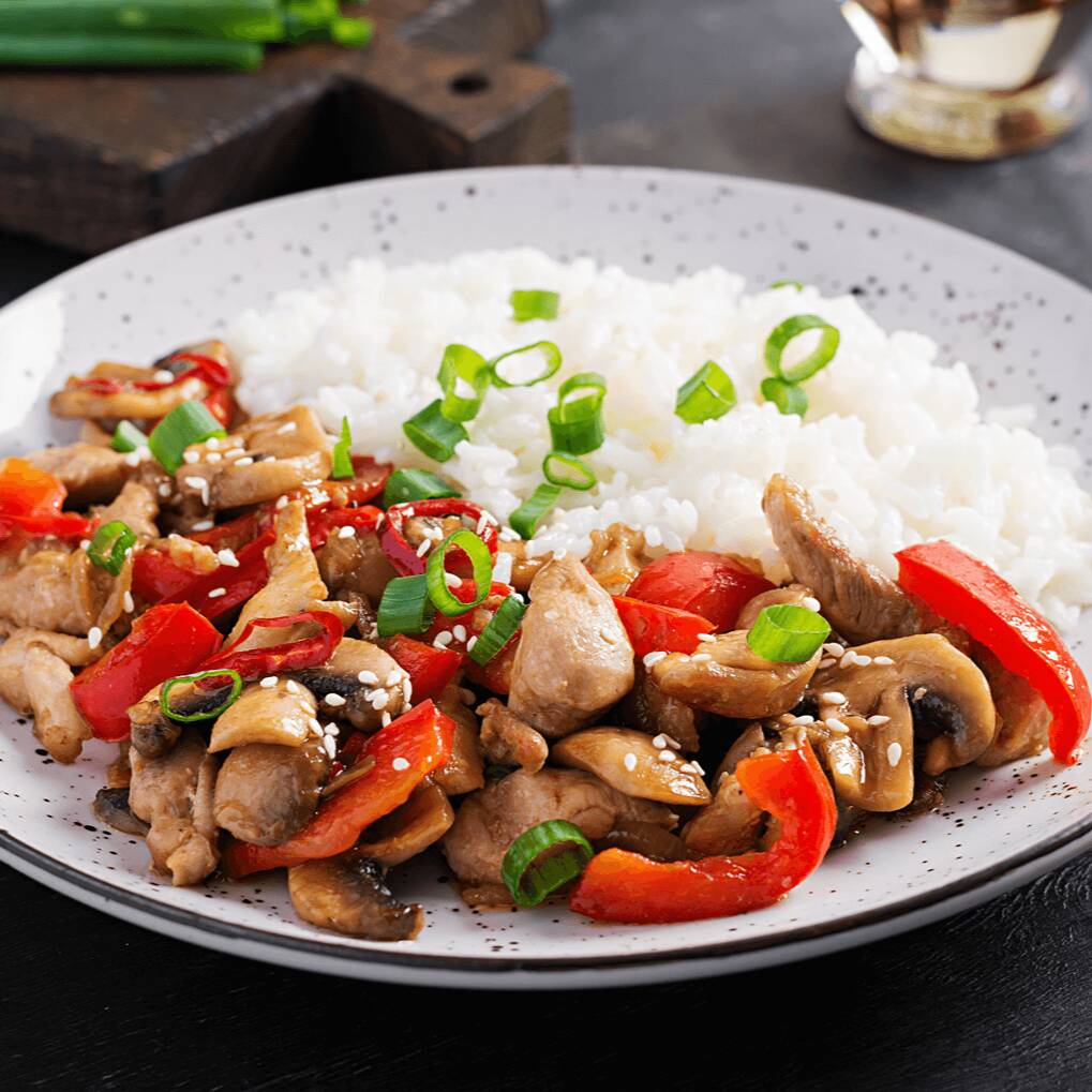 Frango à Xadrez preparado com Legumes Salteados ao Molho Shoyu, Acompanhado de Arroz Branco e Salada Fresca.