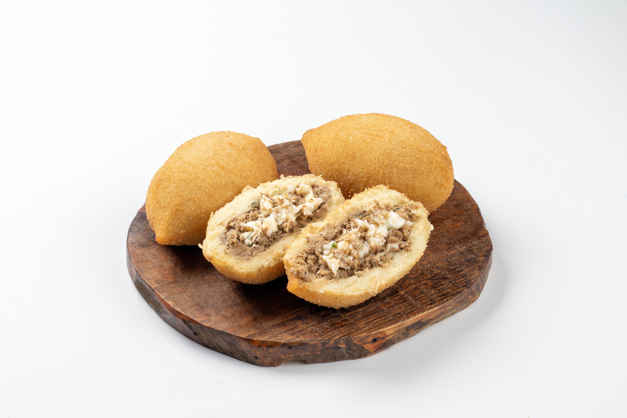Satisfaça sua vontade com a coxinha de carne com requeijão! Com sua massa dourada e crocante, e um recheio generoso de carne desfiada e requeijão cremoso, cada mordida é uma explosão de sabores.