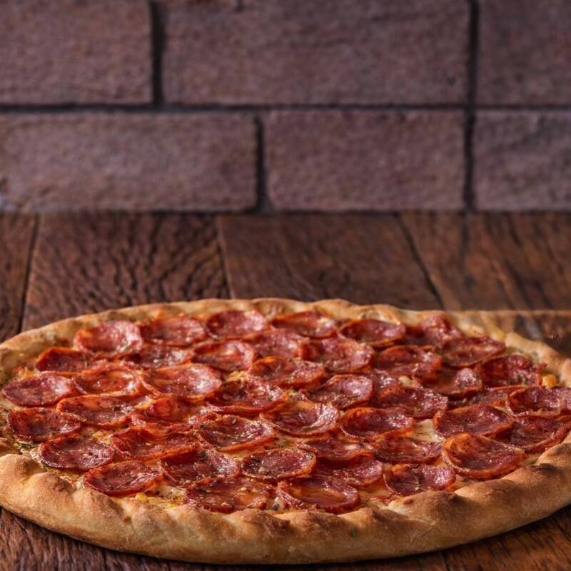 Uma pizza clássica e saborosa com fatias generosas de calabresa suculenta, coberta com cebolas frescas e orégano aromático, tudo sobre uma base de molho de tomate rico.