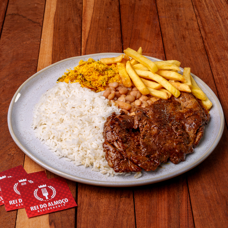 O Chef capricha: bife grelhado suculento com cebola, arroz branco, feijão da casa, farofa crocante e fritas que derretem na boca.