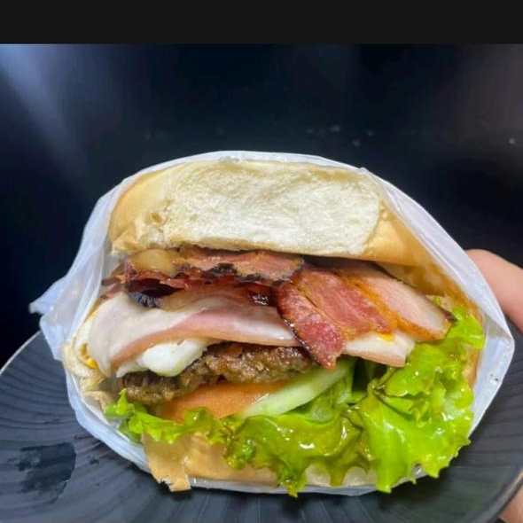 Pão bola, carne, bacon, queijo, presunto, salada.