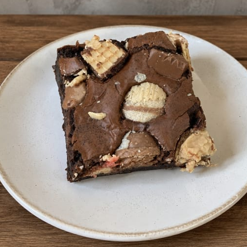 Brownie de chocolate recheado com uma seleção de bombons, criando uma explosão de sabores e texturas a cada mordida.