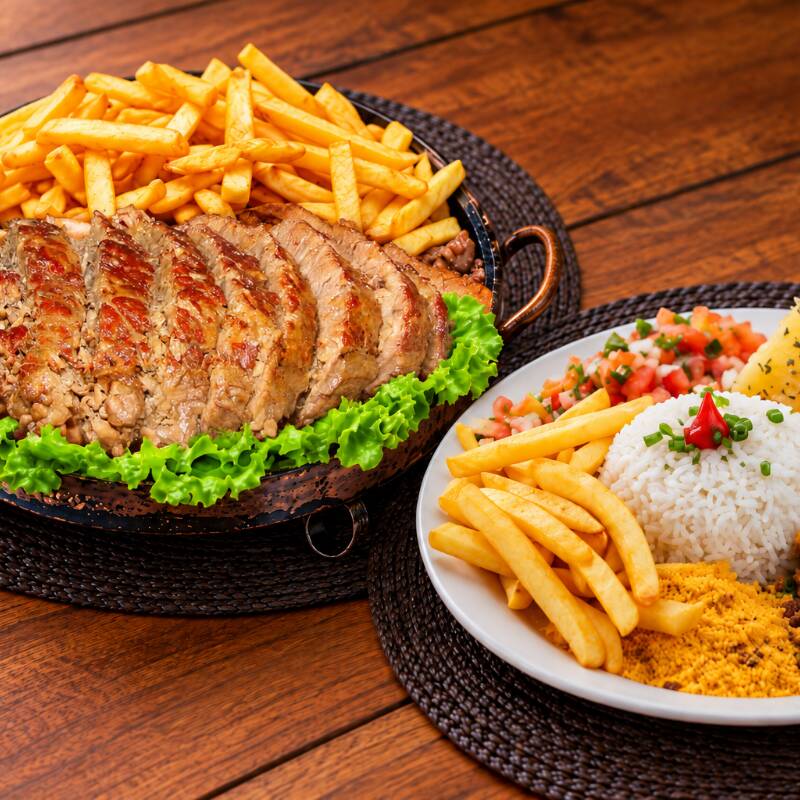 Cupim grelhado acompanhado de arroz branco, feijão tropeiro, batata frita, mandioca cozida e salada simples. Uma refeição completa, bem servida e ideal para compartilhar entre 3 pessoas.
