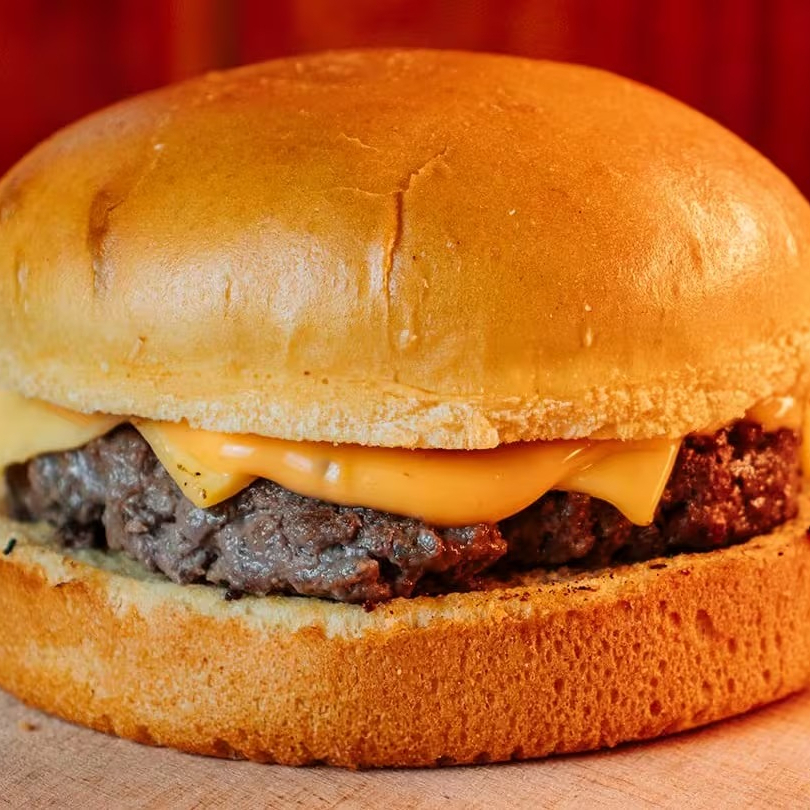 Cheese Burger com hambúrguer de 100g, queijo derretido e pão tradicional, criando uma combinação perfeita de sabor e textura em cada mordida.