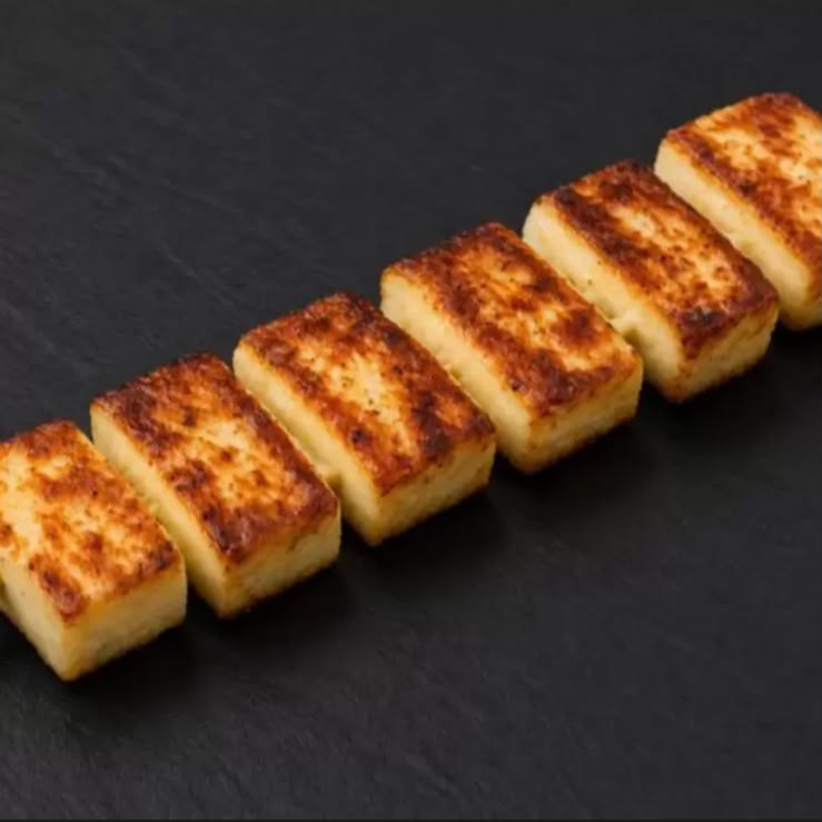 Queijo coalho levemente grelhado no espeto, perfeito para acompanhar uma cerveja gelada.